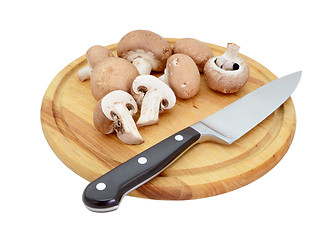 Image showing Whole and halved chestnut mushrooms on board with knife