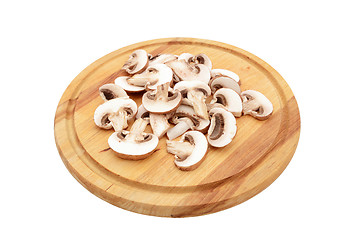 Image showing Sliced chestnut mushrooms on a wooden chopping board