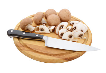 Image showing Whole and sliced chestnut mushrooms on board with knife
