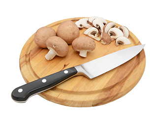 Image showing Knife with whole chestnut mushrooms and slices on board