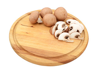 Image showing Sliced and whole chestnut mushrooms on a wooden cutting board