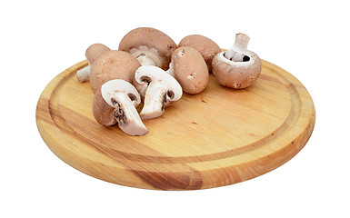Image showing Chestnut mushrooms, whole and halved on a wooden board