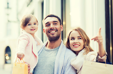 Image showing happy family with child and shopping bags in city