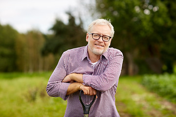 Image showing happy smiling senior man with garden tool at farm