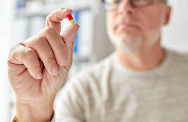 Image showing close up of old man hand with pill