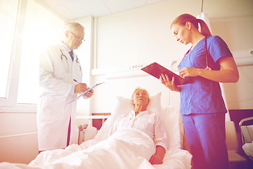 Image showing doctor and nurse visiting senior woman at hospital