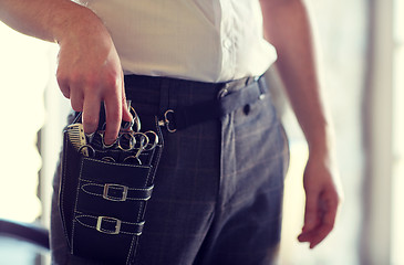 Image showing close up of male stylist with tool case at salon