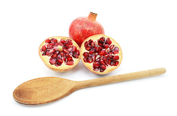 Image showing Pomegranate with two cut halves, with spoon for removing seeds
