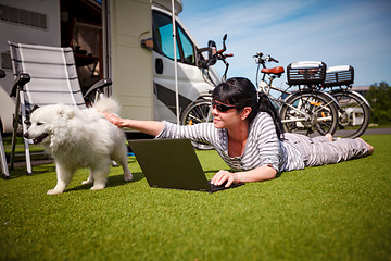 Image showing Woman on the grass with a dog looking at a laptop