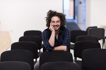 Image showing A student sits alone  in a classroom