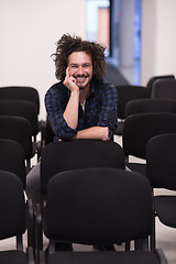 Image showing A student sits alone  in a classroom