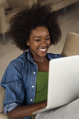 Image showing African American women at home in the chair using a laptop