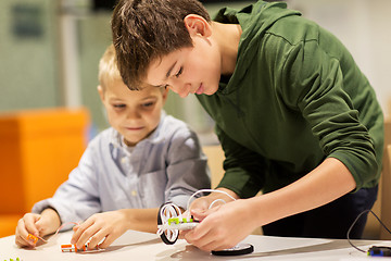 Image showing happy children building robots at robotics school