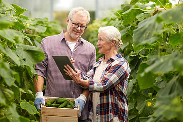 Image showing senior couple with cucumbers and tablet pc on farm