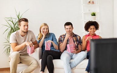 Image showing happy friends with popcorn watching tv at home