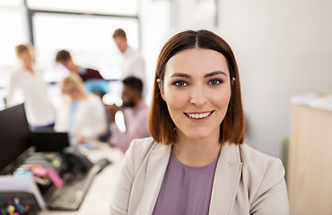 Image showing happy young woman over creative team in office