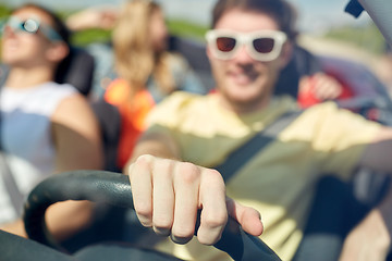 Image showing happy friends driving in convertible car