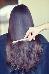 Image showing hand with comb combing woman hair at salon