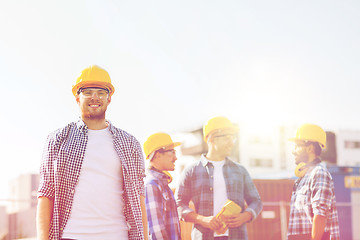 Image showing group of smiling builders in hardhats outdoors