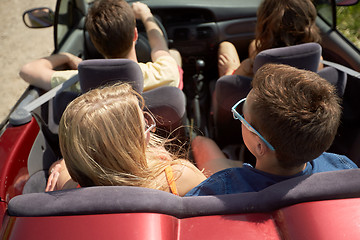 Image showing happy friends driving in convertible car at summer