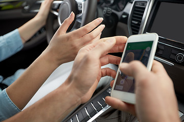 Image showing happy man and woman with smartphone driving in car