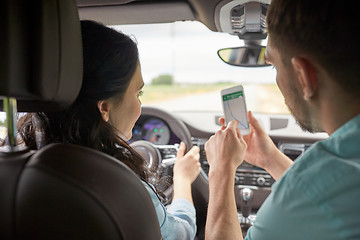 Image showing happy man and woman with smartphone driving in car