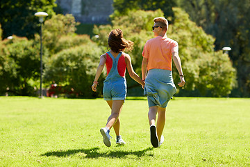 Image showing happy teenage couple walking at summer park