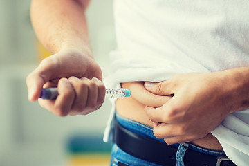 Image showing man with syringe making insulin injection