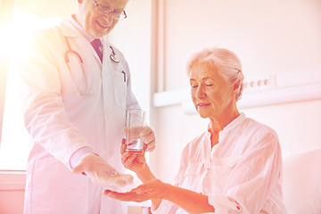 Image showing doctor giving medicine to senior woman at hospital