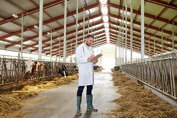 Image showing veterinarian with cows in cowshed on dairy farm