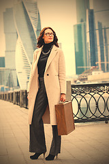 Image showing beautiful smiling businesswoman in a light coat