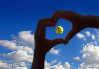 Image showing tennis ball midair with cloudy sky above 