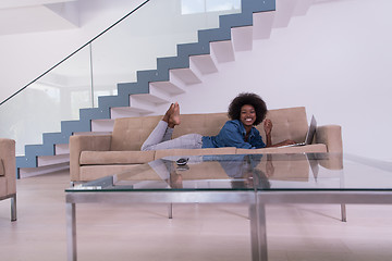 Image showing African American woman using laptop on sofa