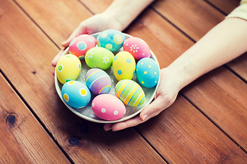 Image showing close up of woman hands with colored easter eggs