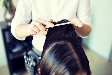 Image showing male stylist hands combing wet hair at salon