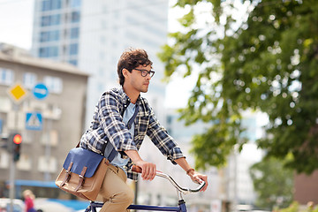 Image showing young hipster man with bag riding fixed gear bike