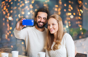 Image showing happy couple with tablet pc and coffee at cafe