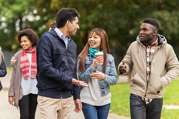 Image showing happy friends walking along autumn park