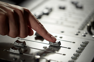 Image showing hand with mixing console in music recording studio