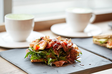 Image showing prosciutto ham salad on stone plate at restaurant