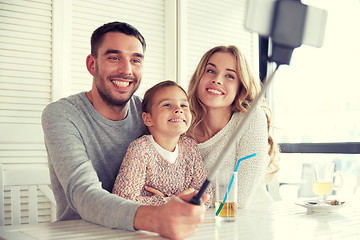 Image showing happy family taking selfie at restaurant