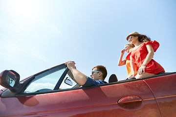 Image showing happy friends driving in cabriolet car outdoors