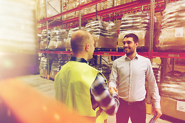 Image showing worker and businessmen with clipboard at warehouse