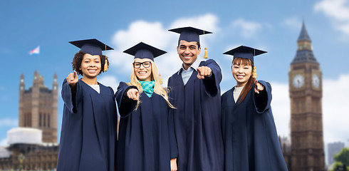 Image showing happy students or bachelors pointing finger at you