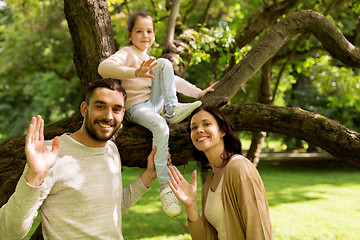 Image showing happy family in summer park waving hands