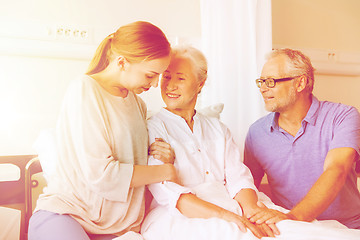 Image showing happy family visiting senior woman at hospital