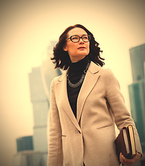 Image showing Smiling dark-haired businesswoman in a bright coat