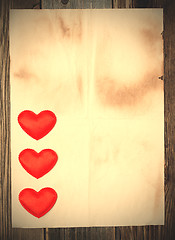 Image showing blank old paper with three red hearts