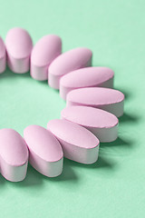 Image showing pink pills on green background