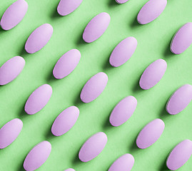 Image showing purple pills on green background